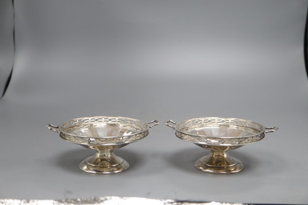 A pair of silver two handled bon bon dishes, with pierced gallery on circular bases, Birmingham 1925, 5.1oz. gross, width 11cm